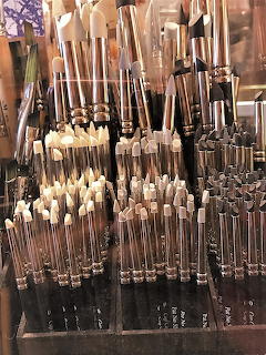 Many artist paintbrushes organized upright in clusters at an art supply store
