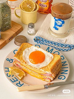 Breakfast sandwich with fried egg on toast served with coffee and lemon tea on white table