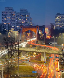 Illuminated Grunwaldzki Bridge in Wrocław at night with car light trails and city buildings