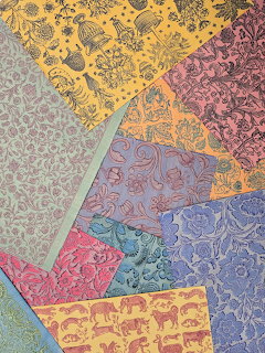Colorful overlapping decorative scrapbooking papers with intricate animal and floral patterns