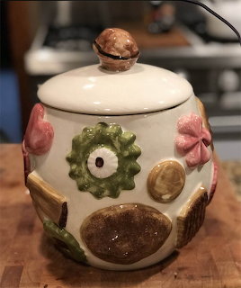 Vintage ceramic cookie jar with mushroom, flower, and leaf decorations on a kitchen counter