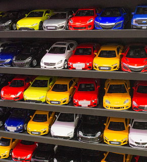 Colorful toy cars lined up on dark display shelves
