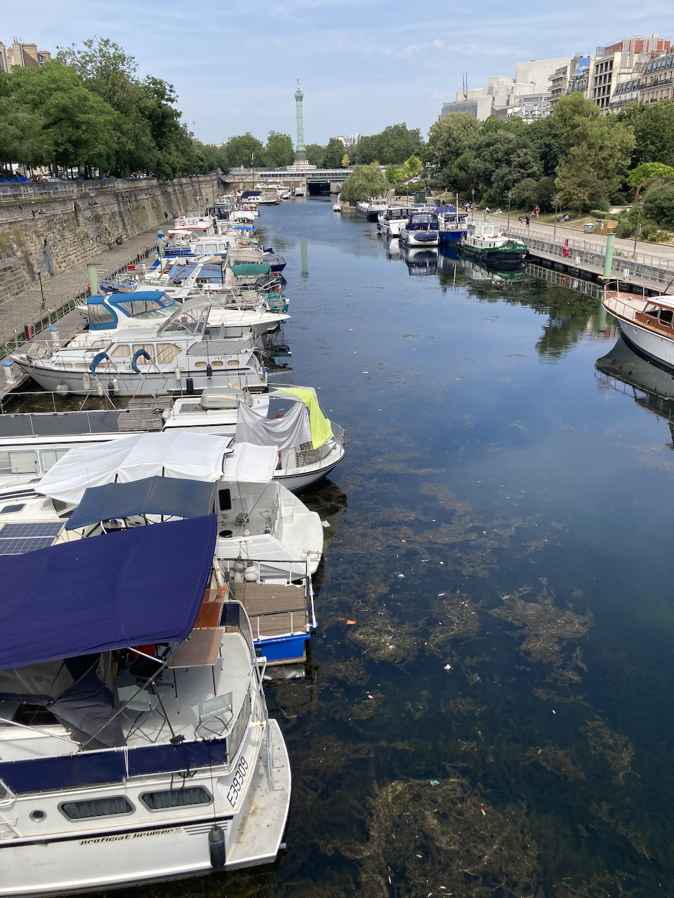 Boats moored at Bassin de l'Arsenal marina in Paris with buildings behind