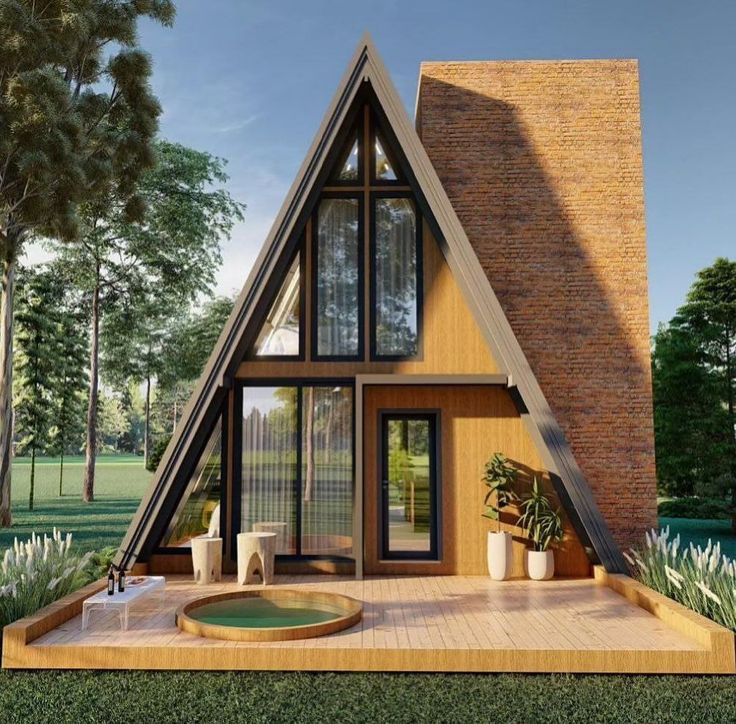 Modern A-frame house with large windows and wooden deck surrounded by trees