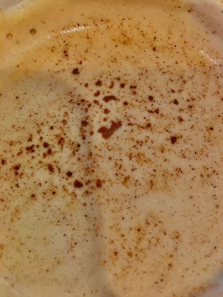Close-up of chai latte with cinnamon sprinkled on foam in white mug