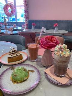 Cafe table with green mousse cake, caramel chesecake, chocolate smoothie, and frappe with marshmallows