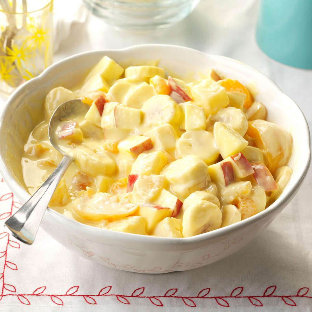 Bowl of creamy fruit salad with banana slices and chopped apples