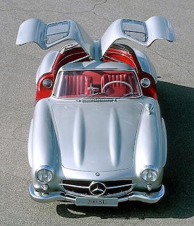 Silver Mercedes-Benz 300SL sports car with both gullwing doors open viewed from above