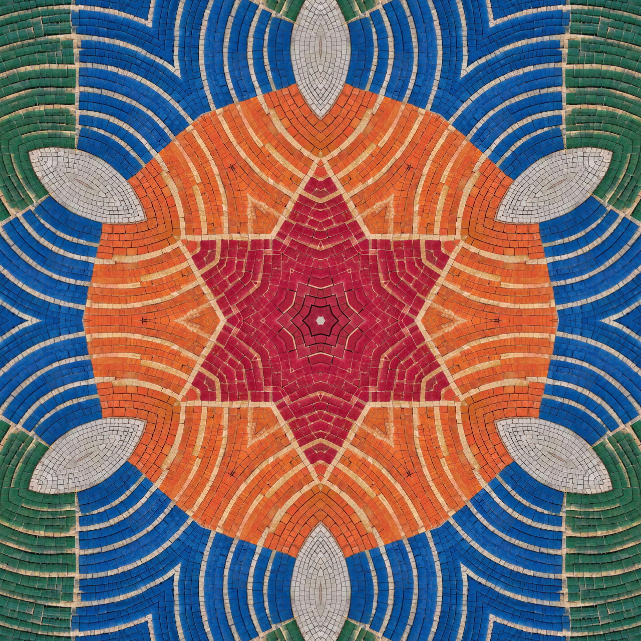 Symmetrical mosaic mandala with orange, pink, blue and green geometric patterns radiating from center star