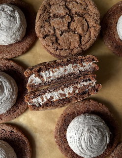 Chocolate sandwich cookies, one split open revealing white cream filling