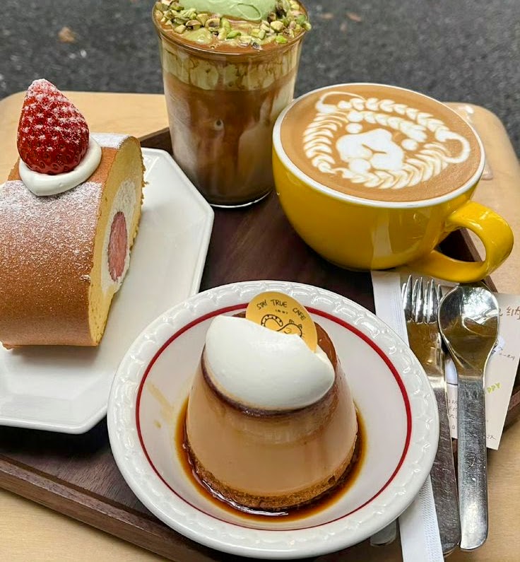 Café tray with latte art, Swiss roll slice, caramel pudding, and iced matcha drink
