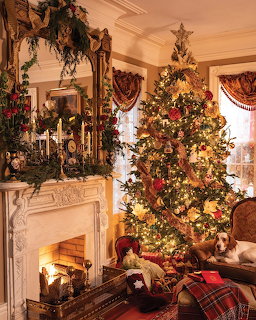 Decorated Christmas tree beside ornate fireplace in Victorian-style room with festive garlands and warm lighting