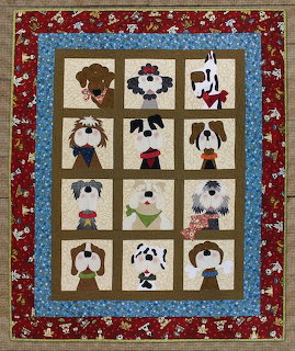 Patchwork quilt with twelve dog face blocks in various patterns, framed by red floral border