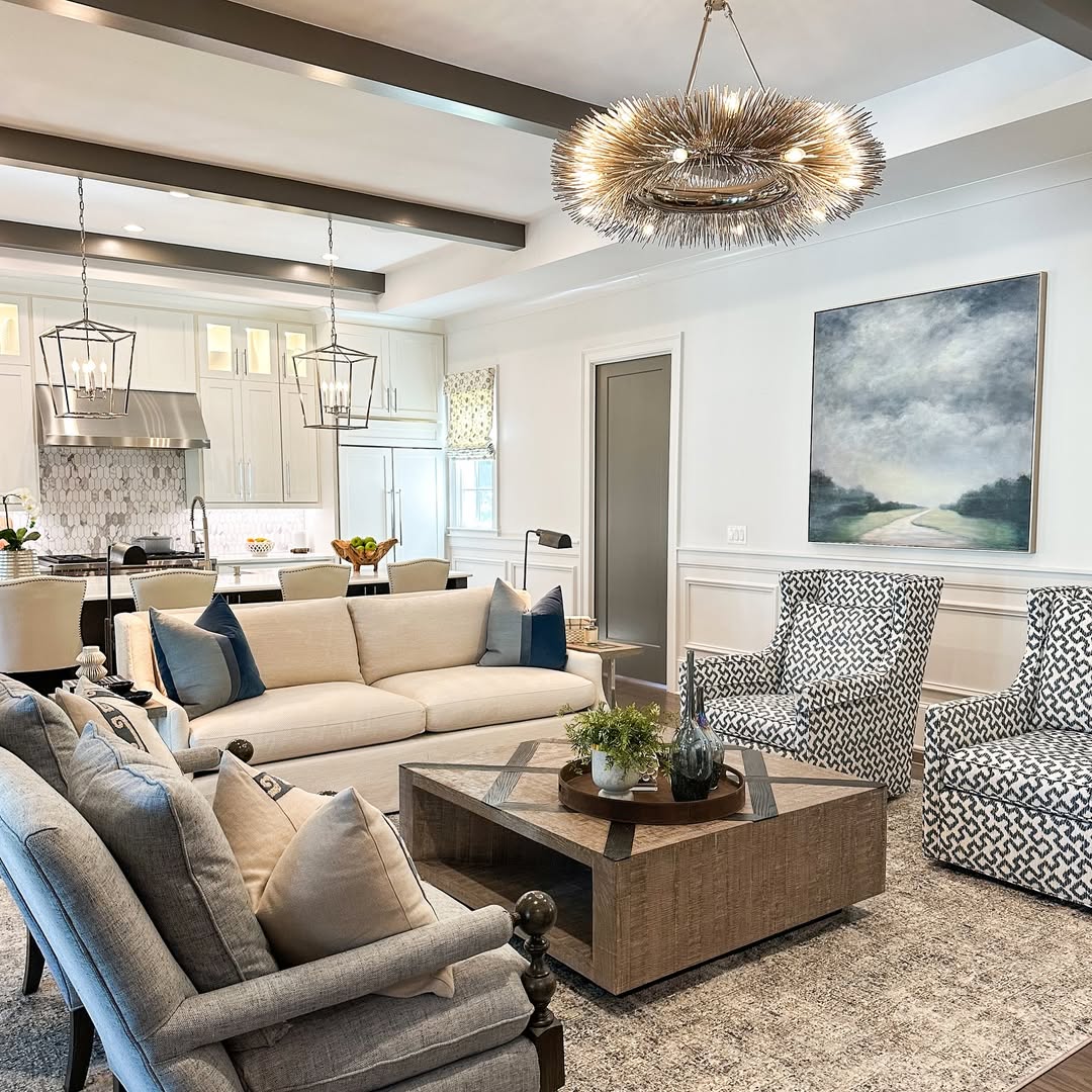 Bright modern living room with sofas, armchairs, coffee table, and open kitchen