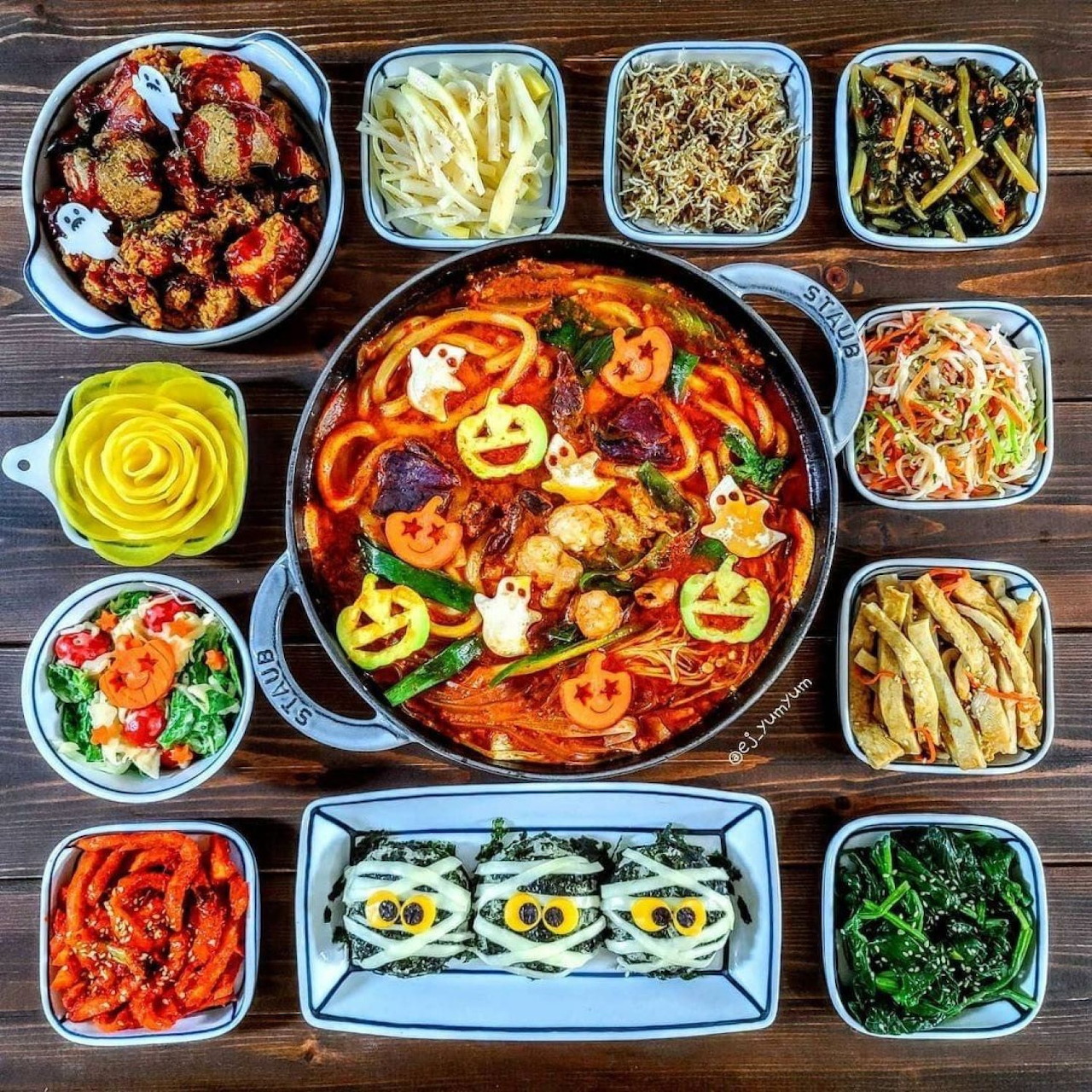 Overhead view of Korean food spread with central spicy stew surrounded by various side dishes in small bowls