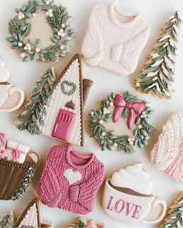 Overhead view of Christmas cookies shaped like sweaters, houses, and trees with festive decorations and miniature wreaths