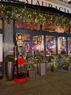Christmas decorated restaurant storefront with nutcracker soldier statue and holiday garland at night
