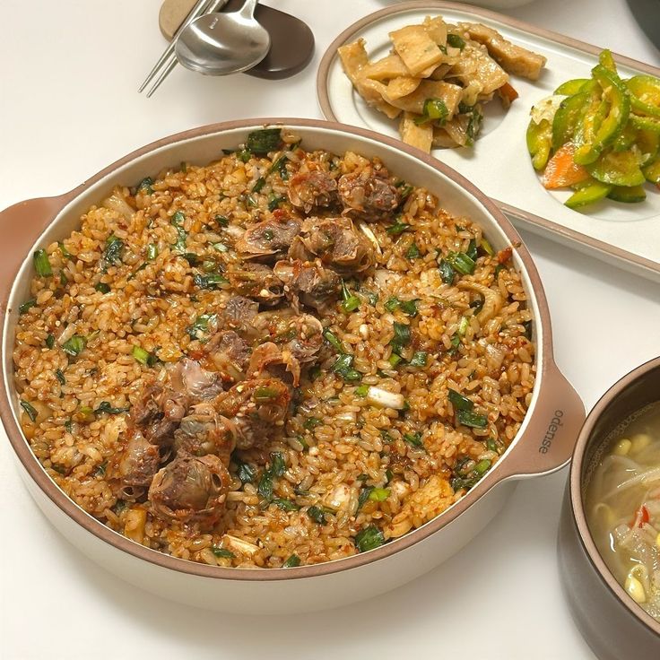 Large pan of Korean seasoned rice with meat, served with side dishes and soup