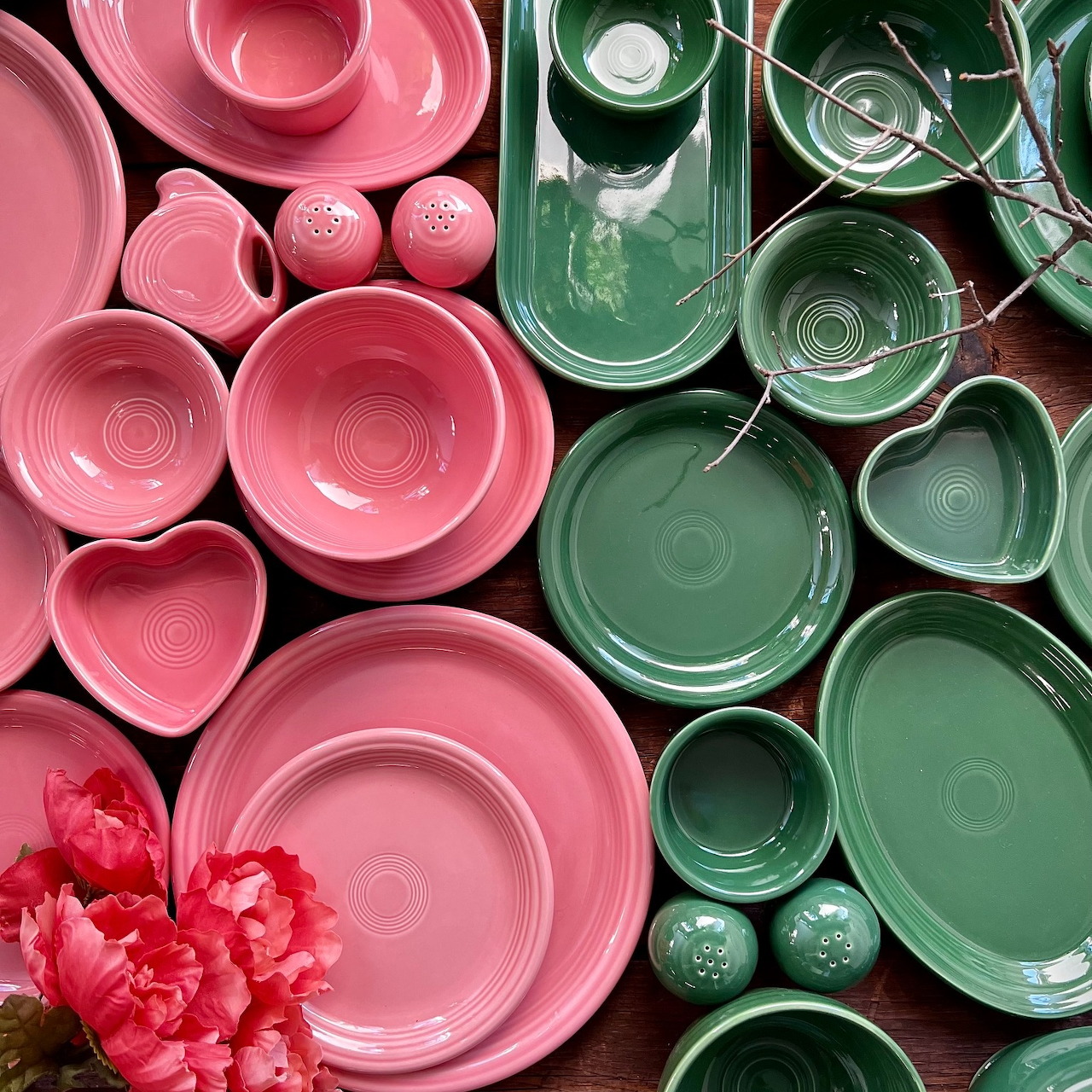 Overhead flat lay of pink and green ceramic plates, bowls, cups, and serving dishes