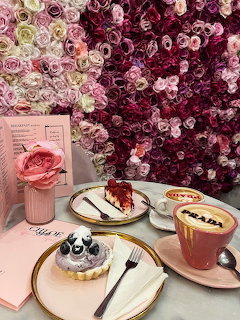 Pink coffee cup with latte art on saucer in pastel setting