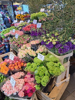 Outdoor flower market stall with colorful bouquets of roses, carnations, and mixed flowers on display