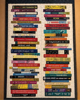 Colorful stack of book spines with various titles arranged horizontally on a dark background