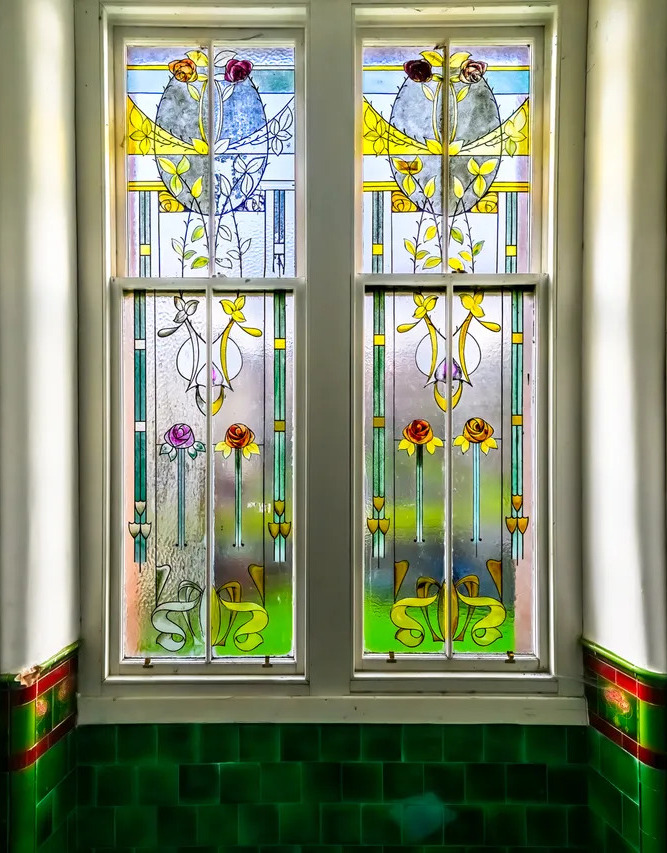 Art Nouveau stained glass window with floral motifs in pastel colors