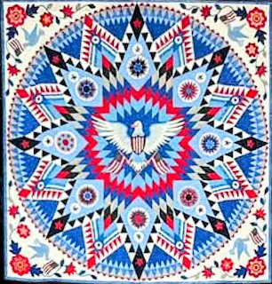 Patriotic quilt with symmetrical eagle and star pattern in red, white, and blue with floral corners