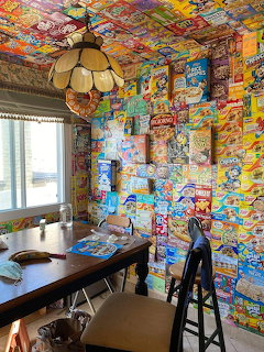 Room interior with walls and ceiling covered in colorful vintage cereal box collages