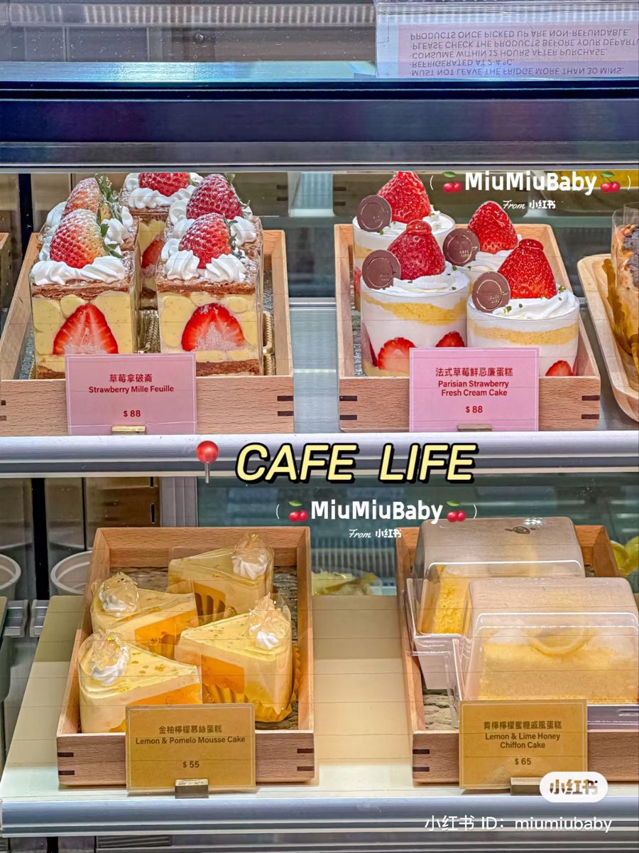 Glass bakery case with strawberry cakes and desserts on shelves with pink price tags