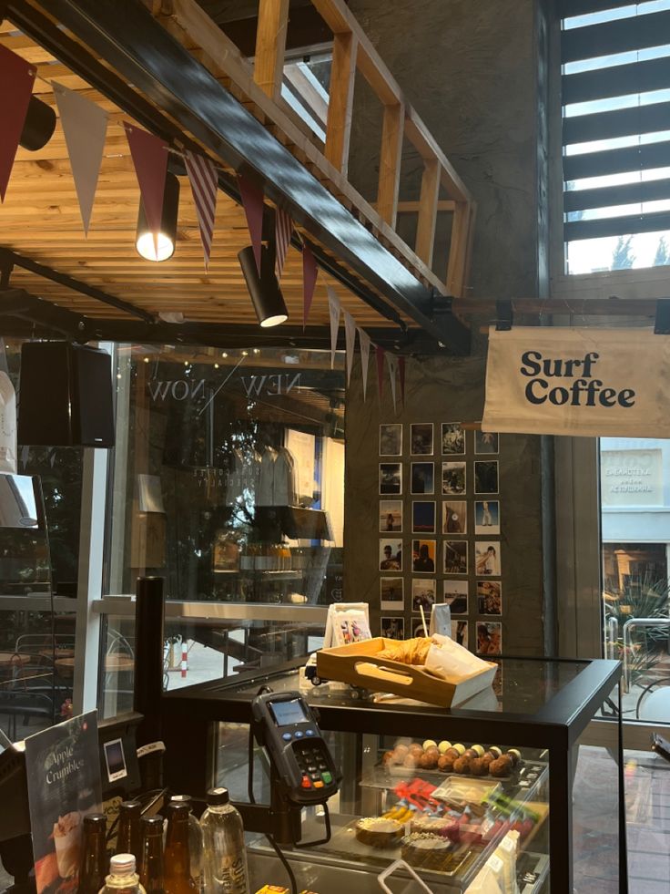 Surf Coffee café interior with counter, pastries, bunting flags, and branded signage