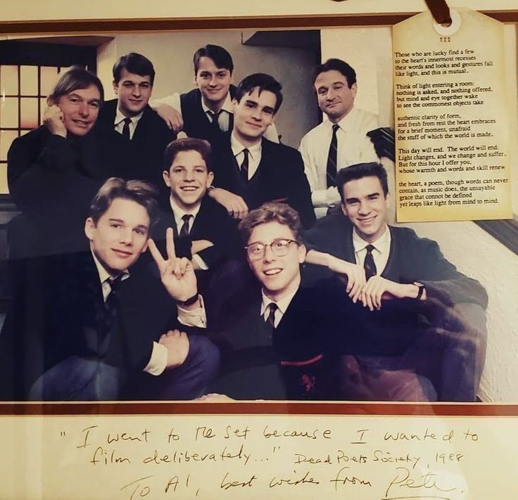 Group of young men in school uniforms posing beside an open book page