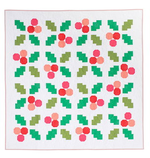 Christmas quilt with green holly leaves and pink berries in repeating pattern on white fabric