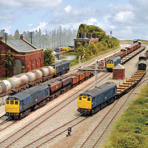 Diesel locomotives and freight wagons on multiple tracks in a detailed model railway yard