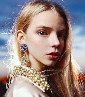 Close-up portrait of a young blonde woman with crystal earrings and jeweled necklace