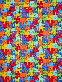 Colorful pattern of interlocking jigsaw puzzle pieces in bright rainbow colors