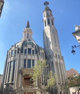 Art Deco church with tall white bell tower and cross in Vichy, France, against blue sky