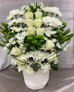 White floral arrangement with chrysanthemums and roses in a white vase