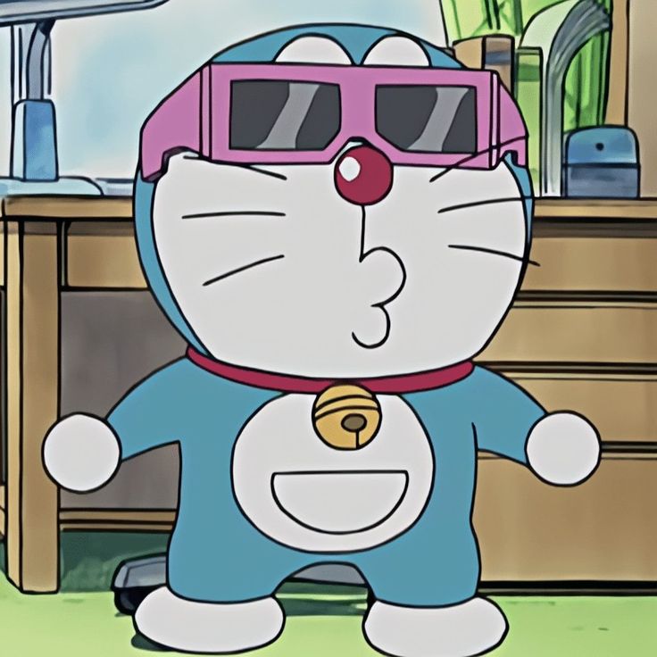 Cartoon Doraemon wearing pink sunglasses indoors in front of a desk