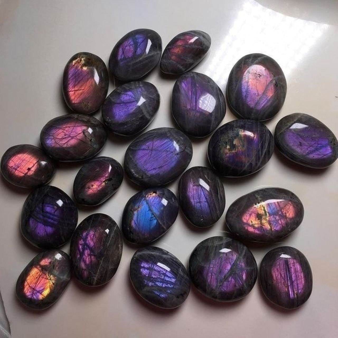Collection of polished purple labradorite stones with colorful iridescent sheen