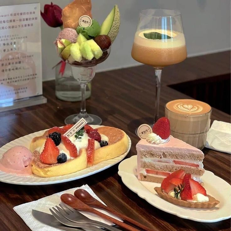 Cafe table with pancakes, cake slices, fruit parfait, and coffee drinks