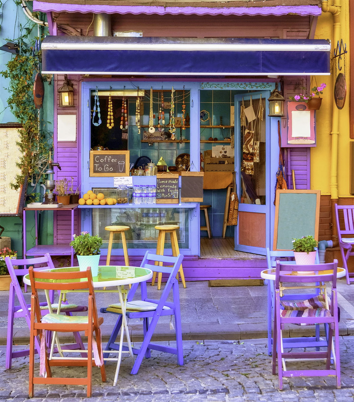 Colorful purple and yellow cafe exterior with outdoor tables and chairs in Istanbul