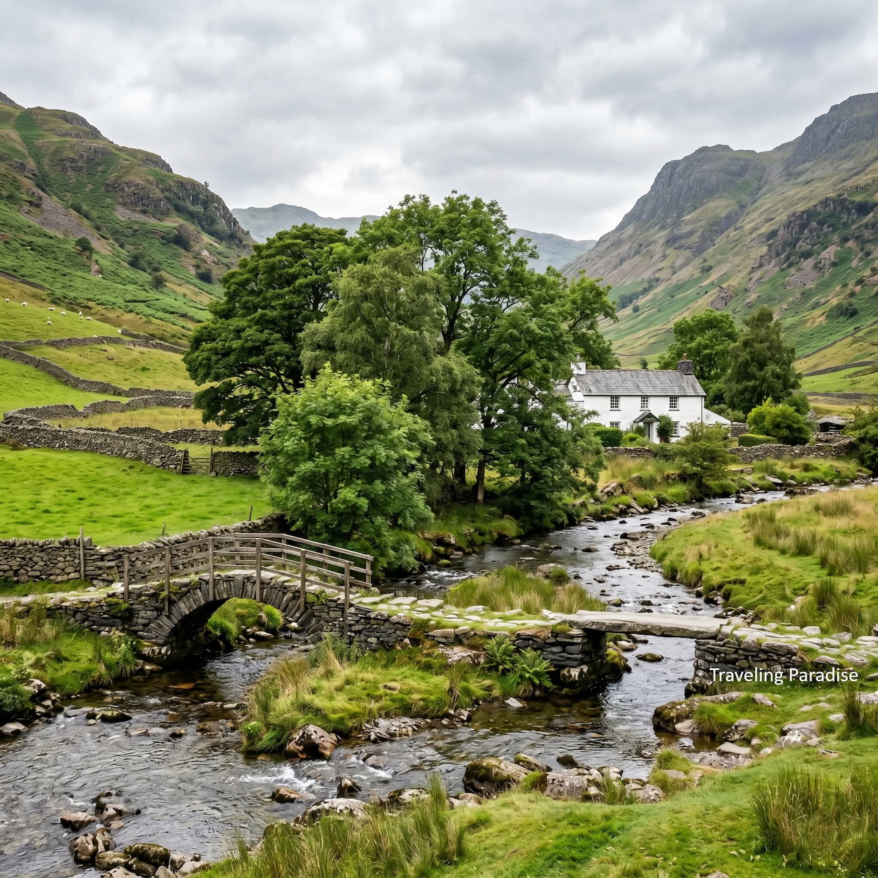 Stone footbridge over a rocky stream with trees and a white cottage in the green Yorkshire Dales