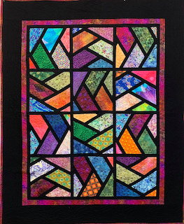 Colorful abstract stained glass window with geometric shapes and black outlines