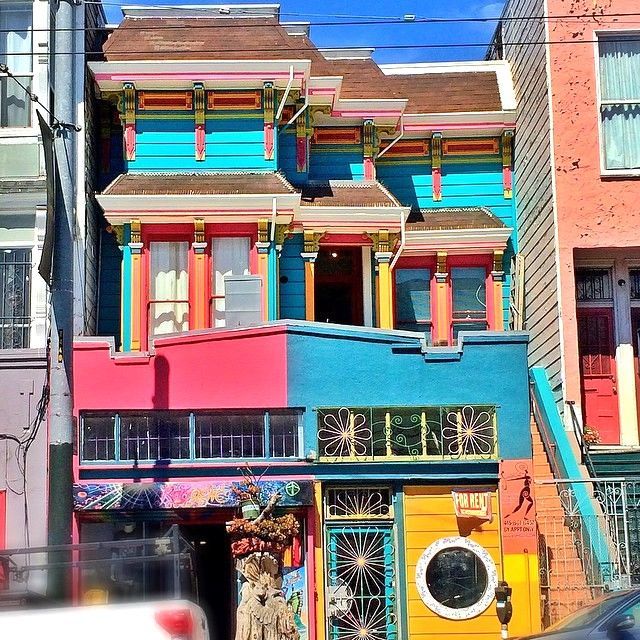 Bright pink and turquoise Victorian townhouses with ornate trim in San Francisco