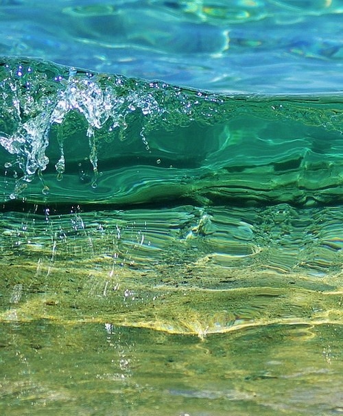 Ocean waves rolling onto a sandy beach under a bright sky