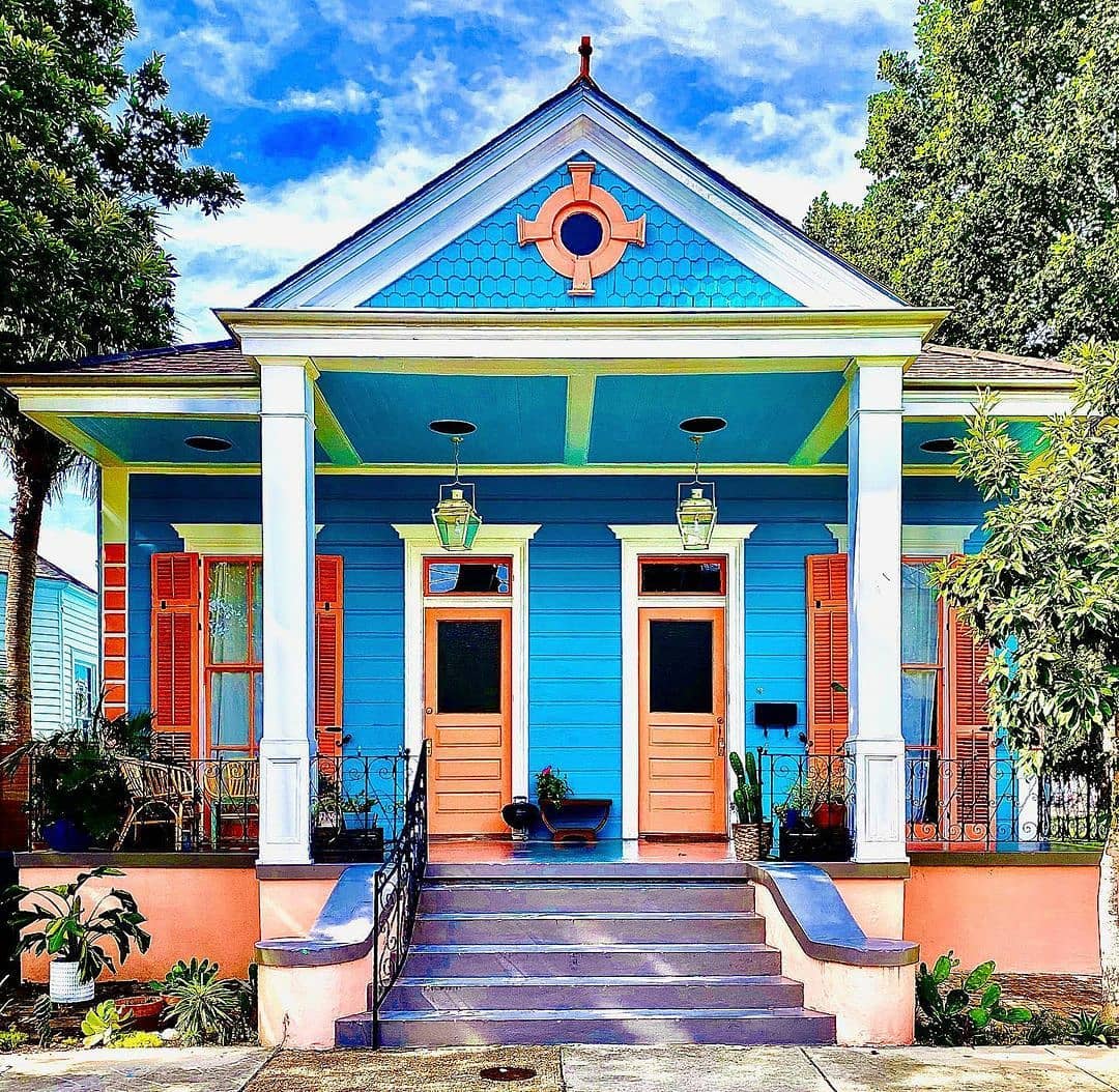 Colorful blue Victorian house with white columned porch and ornate architectural details