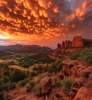 Dramatic orange mammatus clouds over red rock formations and green desert valley at sunset in Sedona