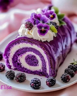 Purple swirl cake roll topped with white cream, purple pansies, and blackberries