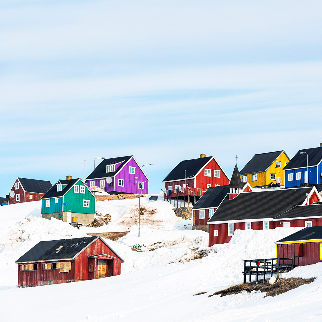 Colorful wooden houses on snowy hillside in Nordic village